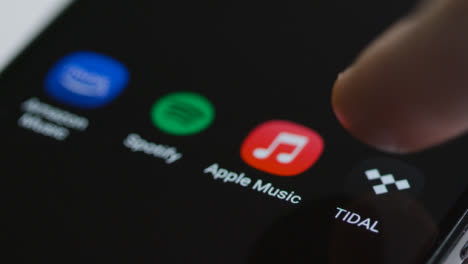 Close-Up-Shot-of-a-Finger-Tapping-Tidal-Music-On-a-Smartphone-Touch-Screen