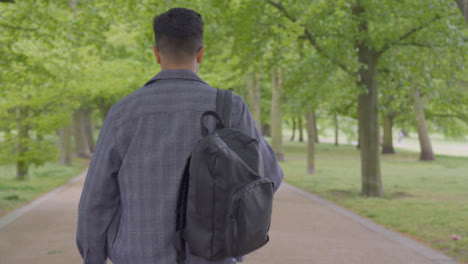 Tracking-Shot-of-Student-Walking-Through-Tree-Lined-Path