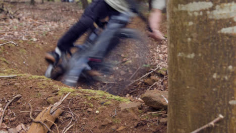 Close-Up-Of-Man-On-Mountain-Bike-Cycling-Along-Dirt-Trail-Through-Woodland
