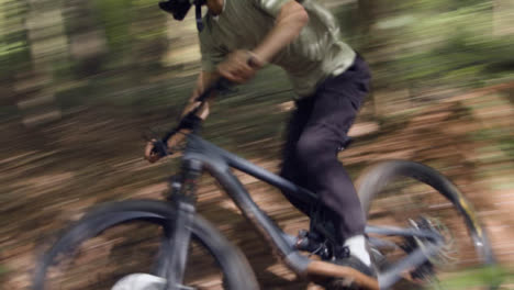 Mann-Auf-Dem-Mountainbike,-Der-Mit-Geschwindigkeit-Auf-Einem-Feldweg-Durch-Den-Wald-Radelt