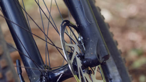 Close-Up-Of-Brake-Disc-On-Wheel-Of-Mountain-Bike-On-Woodland-Trail