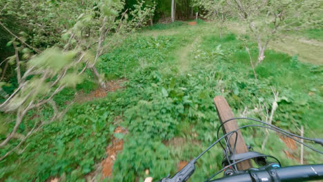 POV-Shot-Of-Man-On-Mountain-Bike-Doing-Mid-Air-Jump-On-Trail-Through-Woodland
