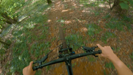 POV-Shot-Of-Man-On-Mountain-Bike-Doing-Mid-Air-Jumps-On-Trail-Through-Woodland-3-