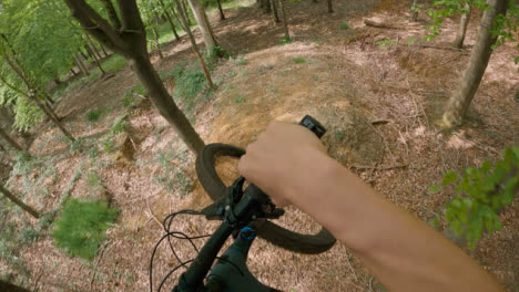POV-Shot-Of-Man-On-Mountain-Bike-Doing-Mid-Air-Jumps-On-Trail-Through-Woodland-5