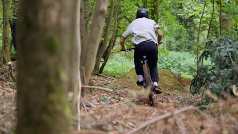 Disparo-En-Cámara-Lenta-De-Un-Hombre-En-Bicicleta-De-Montaña-Haciendo-Un-Salto-En-El-Aire-En-Un-Sendero-De-Tierra-A-Través-Del-Bosque-5