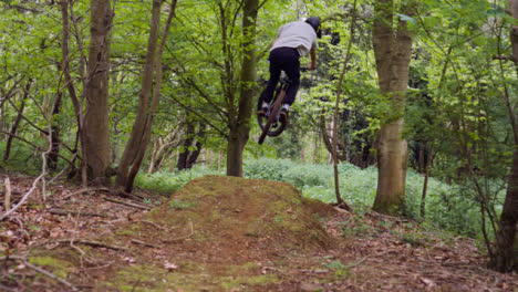 Slow-Motion-Shot-Of-Man-On-Mountain-Bike-Making-Mid-Air-Jump-On-Dirt-Trail-Through-Woodland-9