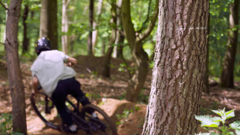 Slow-Motion-Shot-Of-Man-On-Mountain-Bike-Cycling-Along-Trail-Through-Woodland-