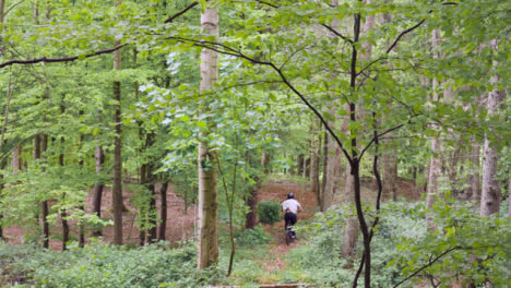 Zeitlupenaufnahme-Eines-Mannes-Auf-Dem-Mountainbike,-Der-Auf-Einem-Feldweg-Durch-Wald-In-Der-Luft-Springt-4