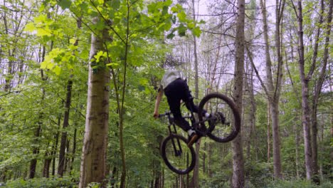 Slow-Motion-Shot-Of-Man-On-Mountain-Bike-Making-Mid-Air-Jumps-On-Dirt-Trail-Through-Woodland-6