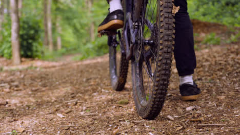 Primer-Plano-De-Cámara-Lenta-Del-Hombre-En-Bicicleta-De-Montaña-En-Bicicleta-A-Lo-Largo-Del-Sendero-A-Través-Del-Bosque