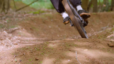 Close-Up-Slow-Motion-Shot-Of-Man-On-Mountain-Bike-Cycling-Along-Trail-Through-Woodland-