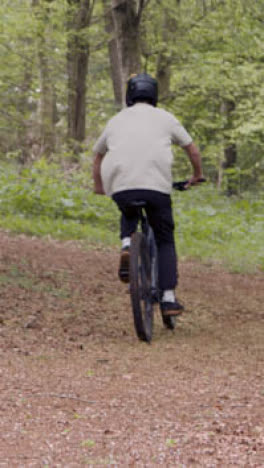 Vertical-Video-Of-Man-On-Mountain-Bike-Cycling-Along-Dirt-Trail-Through-Woodland-5