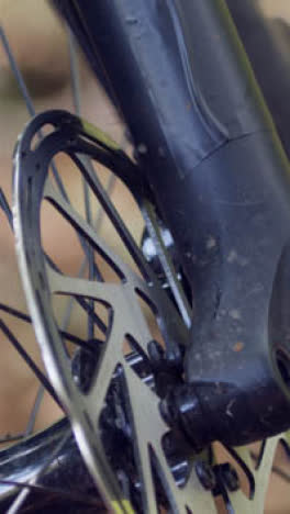 Close-Up-Vertical-Video-Of-Brake-Disc-On-Wheel-Of-Mountain-Bike-On-Woodland-Trail-