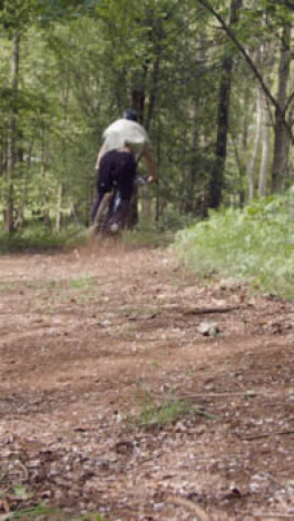 Cerrar-Vídeo-Vertical-Del-Hombre-En-Bicicleta-De-Montaña-En-Bicicleta-A-Lo-Largo-De-Camino-De-Tierra-A-Través-Del-Bosque-2