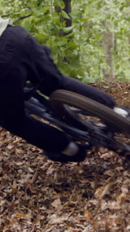 Close-Up-Vertical-Video-Of-Man-On-Mountain-Bike-Cycling-Along-Dirt-Trail-Through-Woodland-3