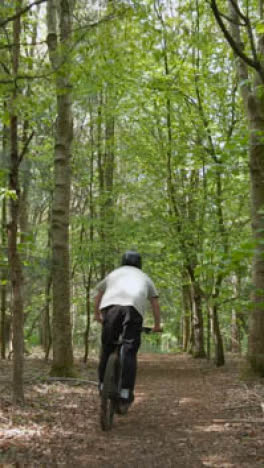 Hombre-De-Seguimiento-De-Video-Vertical-De-Drones-En-Bicicleta-De-Montaña-En-Bicicleta-A-Lo-Largo-Del-Sendero-A-Través-Del-Bosque