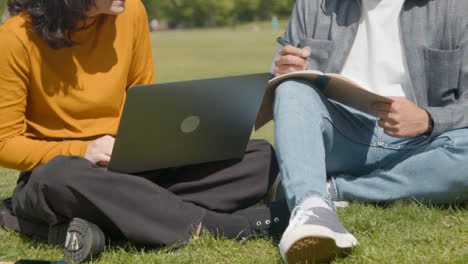 Handheld-Shot-of-Two-Students-Working-Together-In-Park