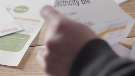Close-Up-Of-Person-At-Table-Opening-Overdue-US-Electricity-Energy-Bill