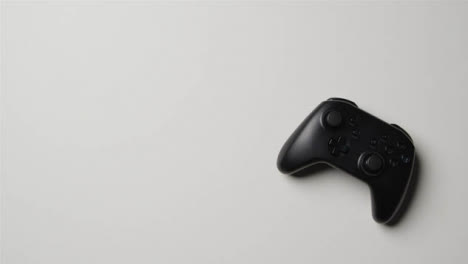 Overhead-Studio-Shot-Of-Hand-Reaching-To-Pick-Up-Video-Game-Controller-1