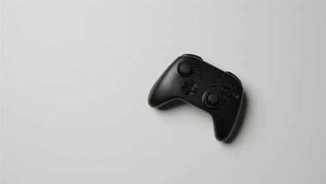 Overhead-Studio-Shot-Of-Hand-Putting-Video-Game-Controller-White-Background