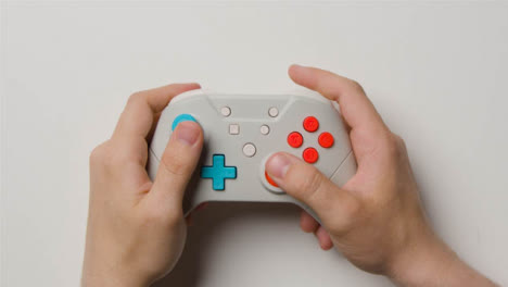 Overhead-Studio-Shot-Of-Hands-Using-And-Playing-Video-Game-Controller-3