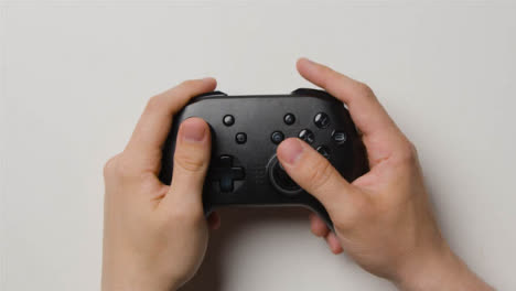 Overhead-Studio-Shot-Of-Hands-Using-And-Playing-Video-Game-Controller-5
