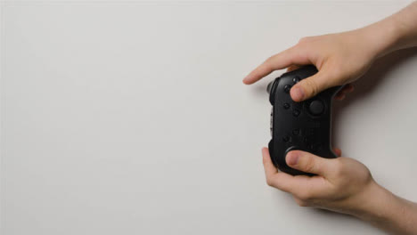 Overhead-Studio-Shot-Of-Hands-Using-And-Playing-Video-Game-Controller-5