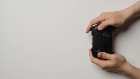 Overhead-Studio-Shot-Of-Hands-Using-And-Playing-Video-Game-Controller-6