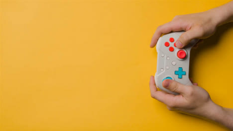 Overhead-Studio-Shot-Of-Hands-Using-And-Playing-Video-Game-Controller-7