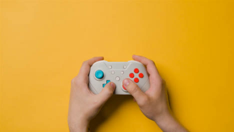 Overhead-Studio-Shot-Of-Hands-Using-And-Playing-Video-Game-Controller-8