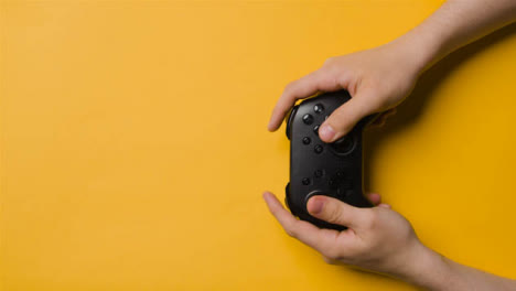 Overhead-Studio-Shot-Of-Hands-Using-And-Playing-Video-Game-Controller-9