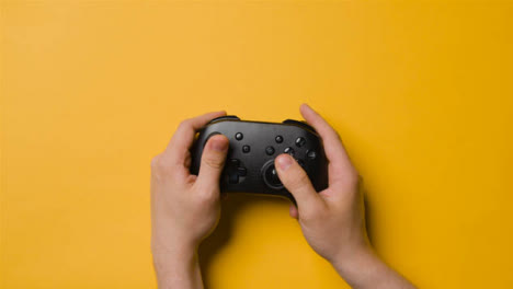 Overhead-Studio-Shot-Of-Hands-Using-And-Playing-Video-Game-Controller-10