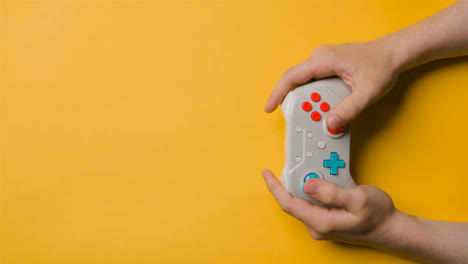 Overhead-Studio-Shot-Of-Hands-Using-And-Playing-Video-Game-Controller-11