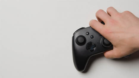 Overhead-Studio-Shot-Of-Hand-Reaching-In-To-Pick-Up-Video-Game-Controller-9