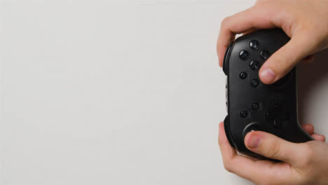 Overhead-Studio-Hands-Picking-Up-And-Playing-With-Video-Game-Controller