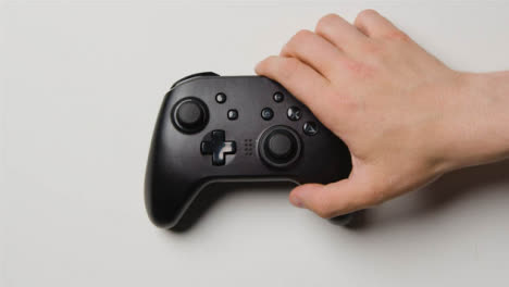 Overhead-Hand-Reaching-In-To-Pick-Up-Video-Game-Controller-10