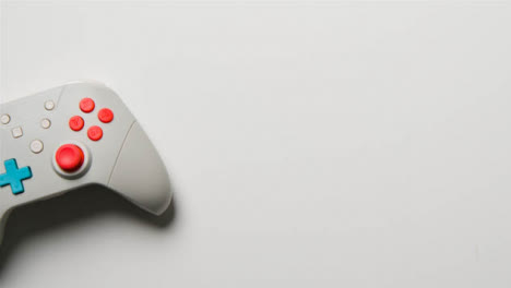 Overhead-Studio-Shot-Of-Hand-Reaching-In-To-Pick-Up-Video-Game-Controller-14