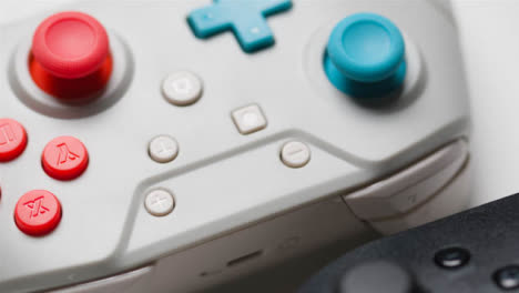 Studio-Close-Up-Of-Two-Video-Game-Controllers-On-White-Background