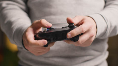 Frente-A-Las-Manos-De-Cerca-Mientras-El-Hombre-Juega-Con-El-Controlador-De-Videojuegos-En-Casa-10