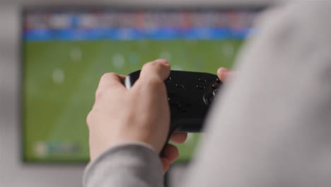 Close-Up-Hands-Man-Playing-Sports-Video-Game-Controller-Screen-Background-1