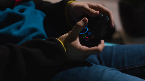 Side-On-Close-Up-Hands-Man-Playing-Video-Game-Controller-Sitting-Sofa-At-Home-1
