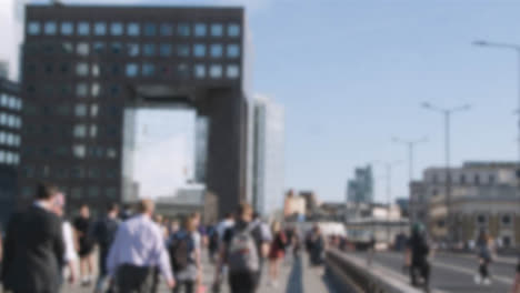 Defocused-Shot-Commuters-Walking-London-Bridge-Office-Buildings-In-Background