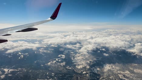 Ansicht-Flugzeug-Fenster-Schneebedeckte-Berge-Winter-Skigebiet-Urlaub-Urlaub-1