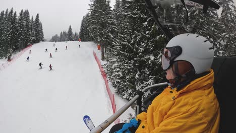 Skifahrer-Am-Sessellift-über-Den-Schneebedeckten-Berg-Unten