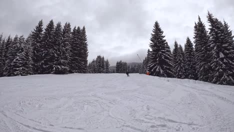 Skier-Skiing-Down-Mountain-And-Covering-Camera-With-Snow