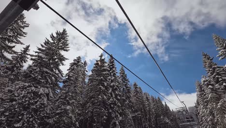 Ski-Chair-Lift-Above-Snow-Covered-Mountain-And-Trees