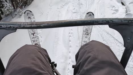 POV-Aufnahme-Eines-Skifahrers-Am-Sessellift-über-Schneebedeckte-Berge-Und-Bäume-1