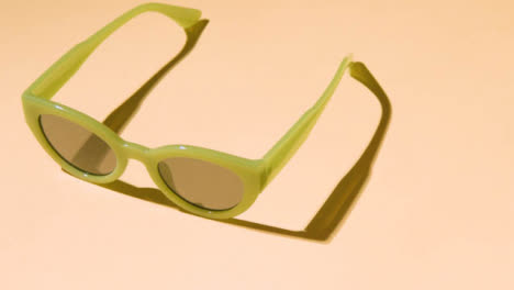 Summer-Holiday-Vacation-Concept-Of-Green-Sunglasses-On-Yellow-Background
