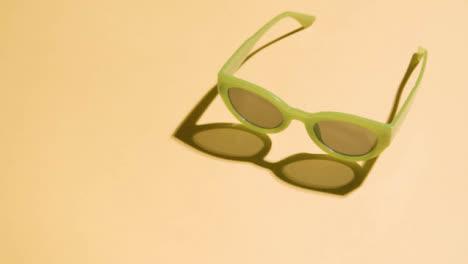 Summer-Holiday-Vacation-Concept-Of-Green-Sunglasses-On-Yellow-Background-4