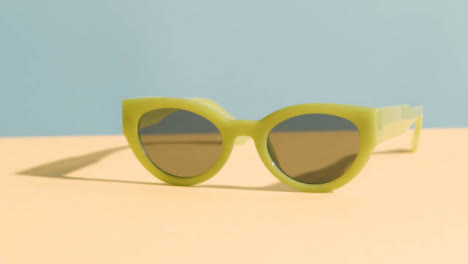 Summer-Holiday-Vacation-Concept-Of-Sunglasses-On-Yellow-Blue-Background